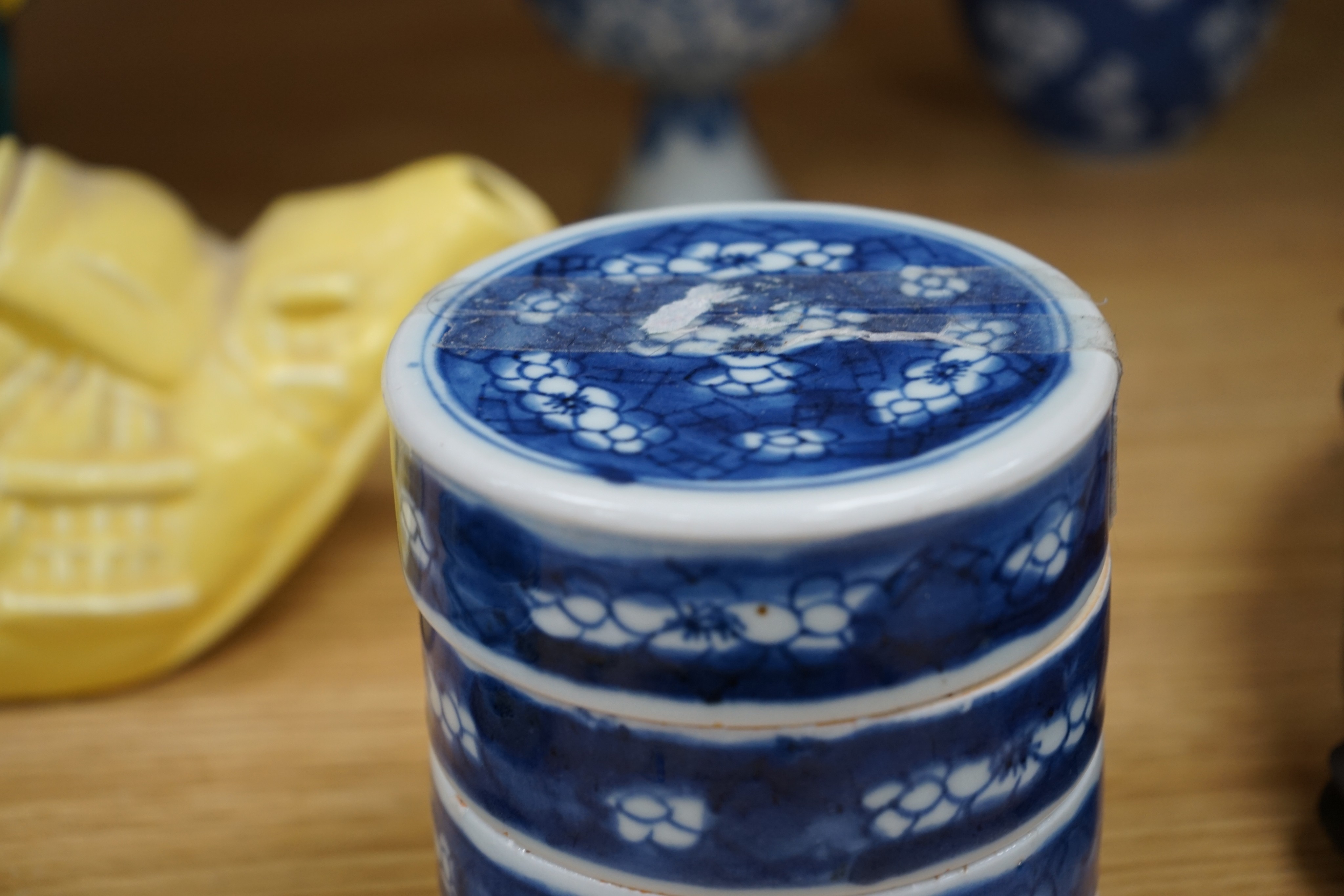 A Chinese blue and white ovoid jar and cover and similar stacking box, Kangxi and a Qing blue and white footed cup, tallest 15cm